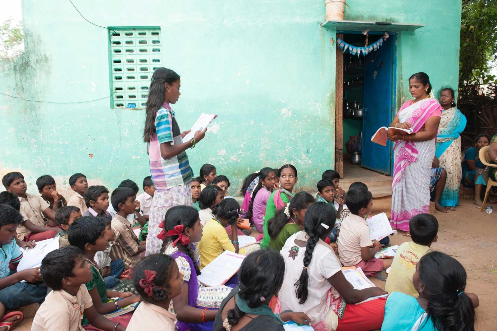 Annandhi reads from a book, in night school