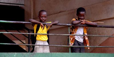 Two boys standing behind a barrier