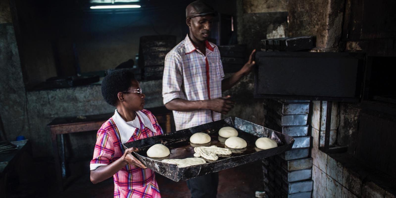 Evelyn holds tray with bread