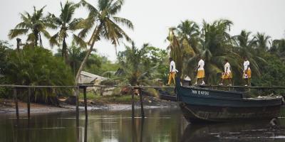 Four young Child Rights Ambassadors walk on a bridge across the water.