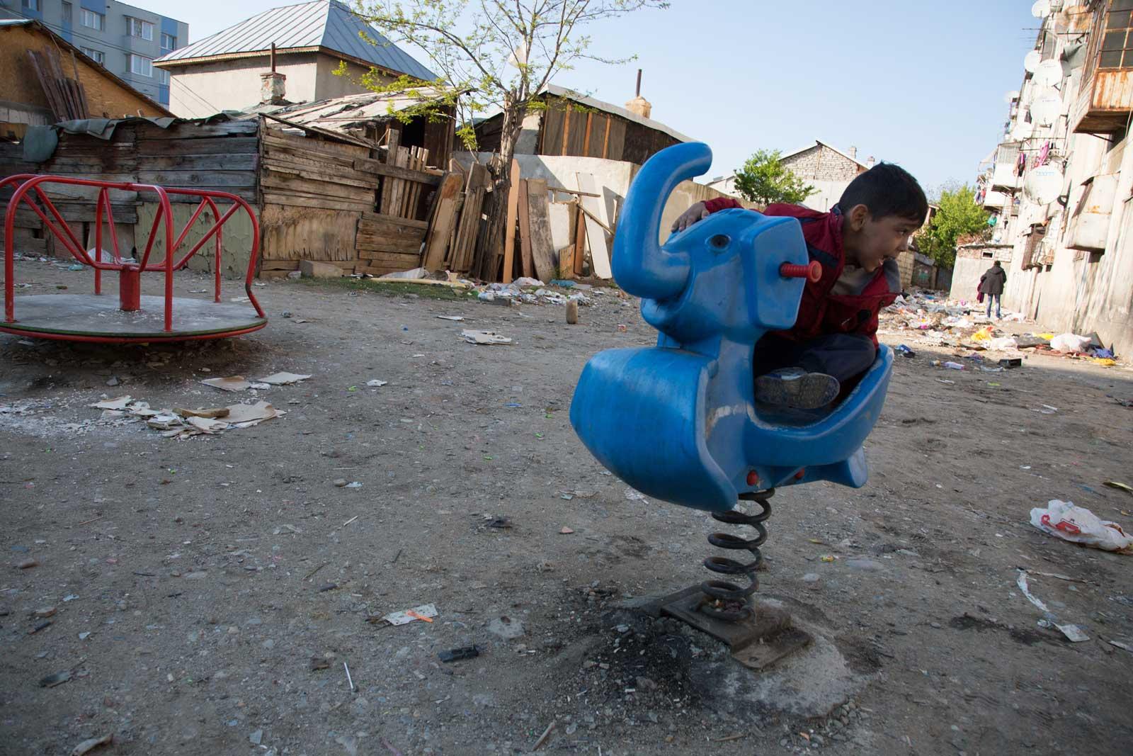Child playing in run-down playground.