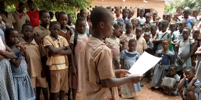Boy talking to large group of children