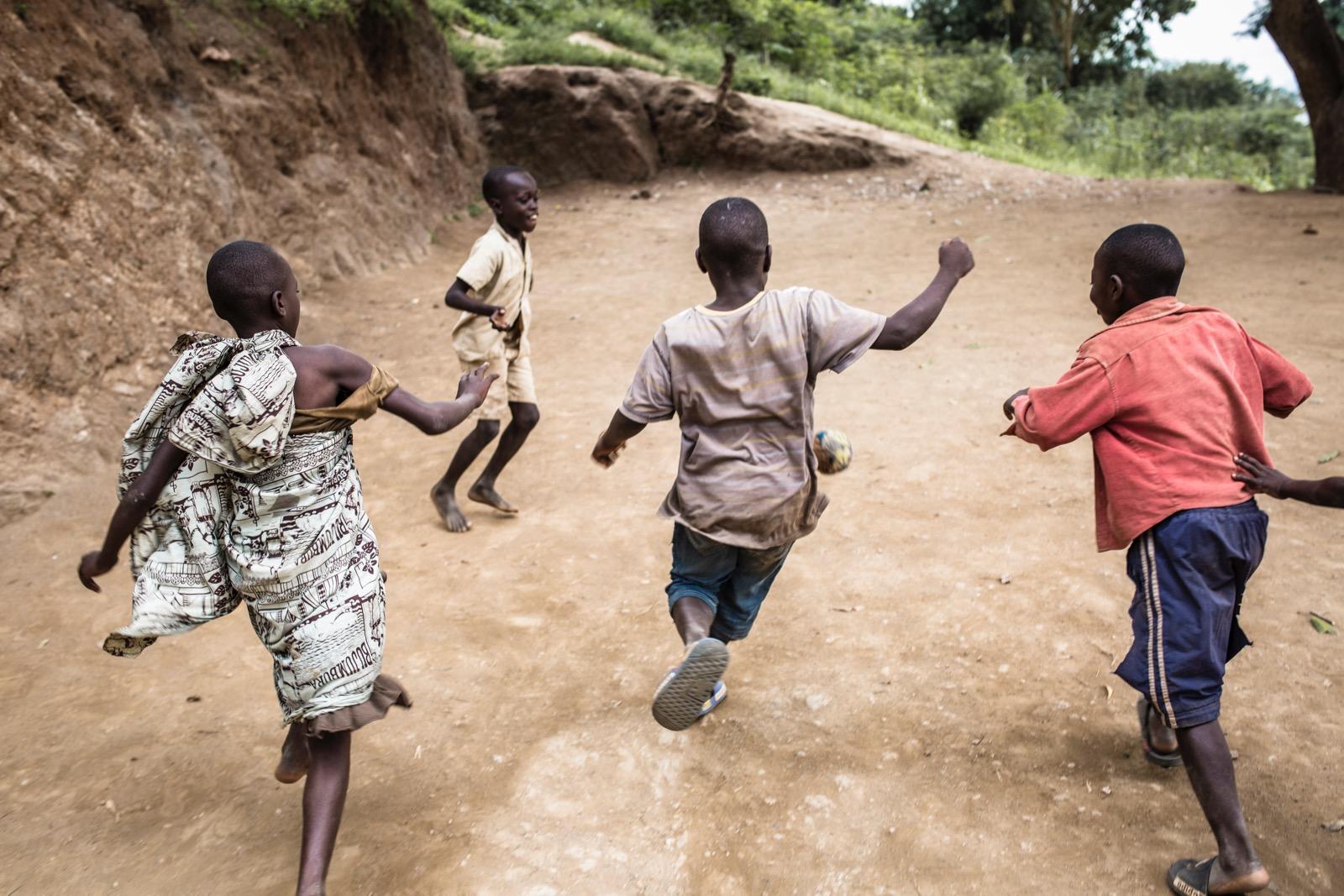A bunch of children running outside.