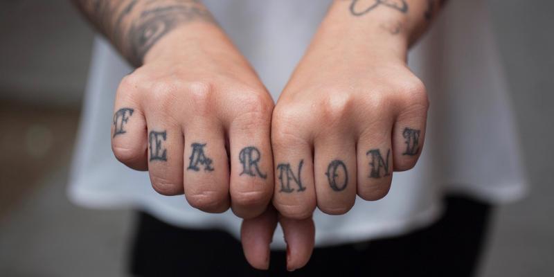 Girl holding out hands with tatoos