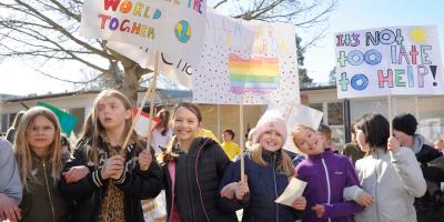 girls smiling and holding placards 
