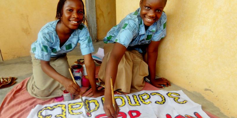 Two girls painting poster