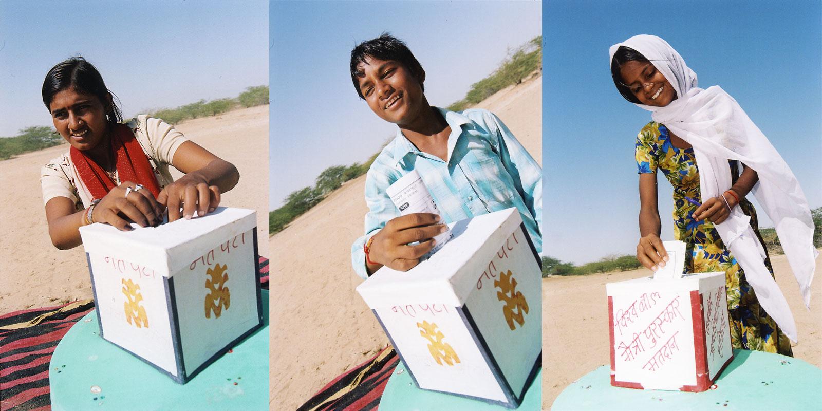 three people putting in votes in ballot box