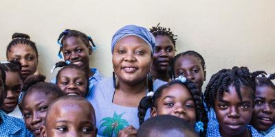 Guylande posing with some children.