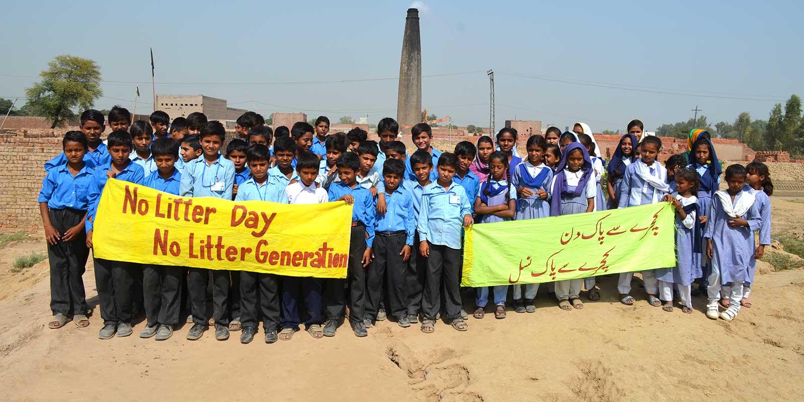 Children standing with signs saying No Litter Generation