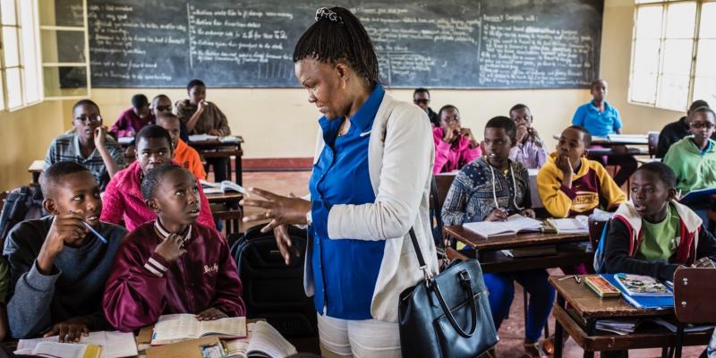 Spès and children in a classroom.
