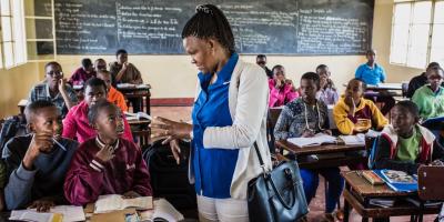 Spès and children in a classroom.