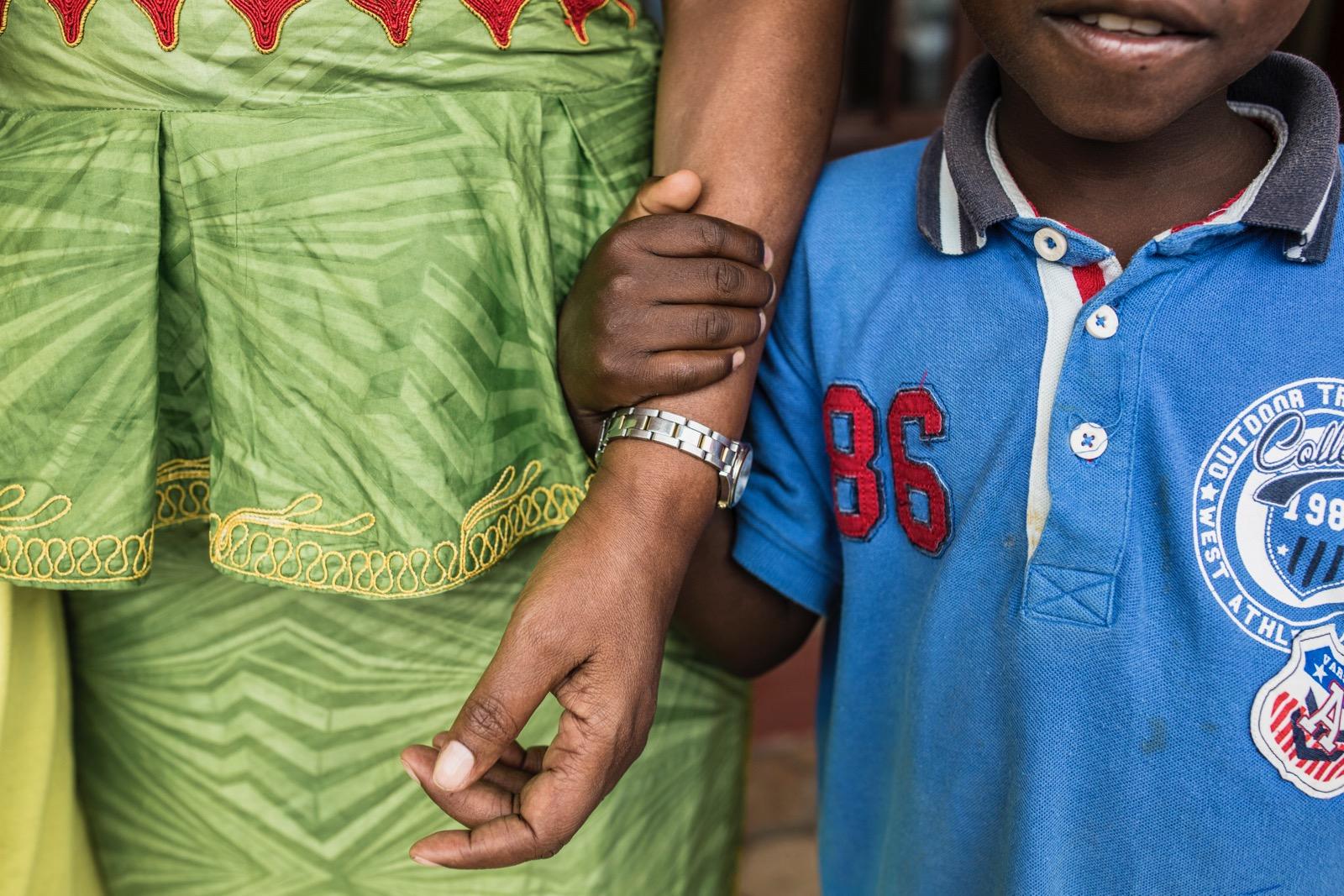 A child holding a grown-ups arm