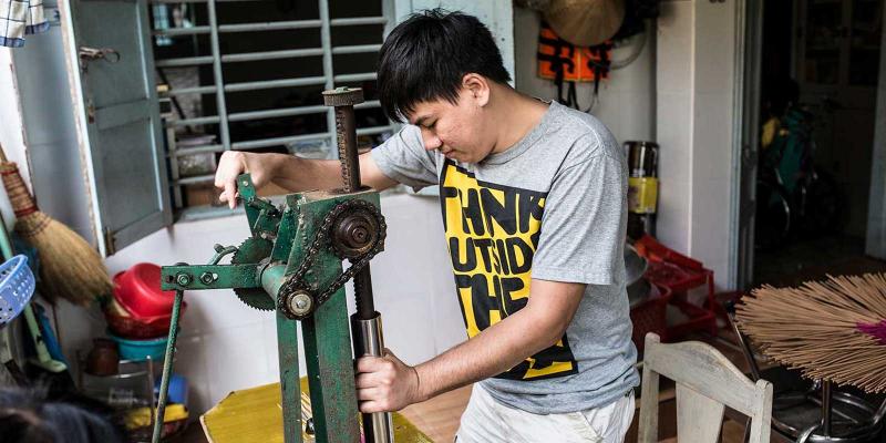 Young boy in Vietnam making incense sticks.