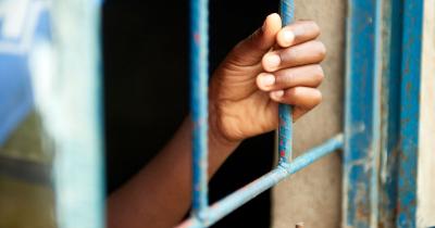 Hand holding bars on window